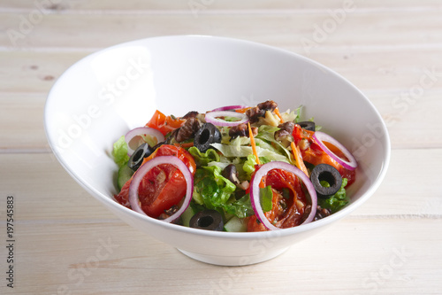 Salad with fried tomato, walnuts, cucumber, onion and olives