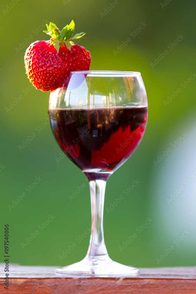 A glass of wine with strawberries outdoors A glass of wine with strawberries outdoors