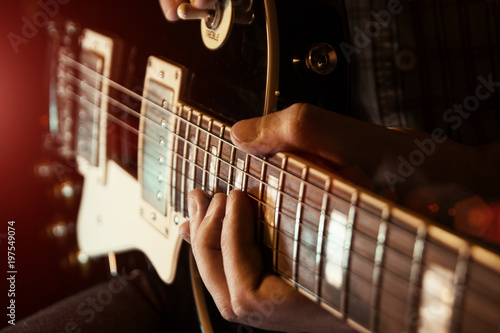 Musician man is playing the guitar on the concert photo