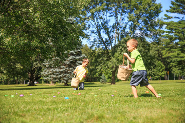 children hunt for Easter eggs. happy kids pick up colorful eggs. the concept of Easter Egg Hunt. copy space for your text