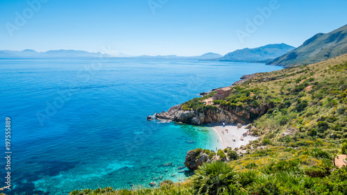 The perfect secret beach: white pebbles beach and turquoise sea, surrounded by luxuriant vegetation of the natural reserve “Riserva dello Zingaro”, San Vito Lo Capo, Sicily, Mediterranean Sea, Italy. photo