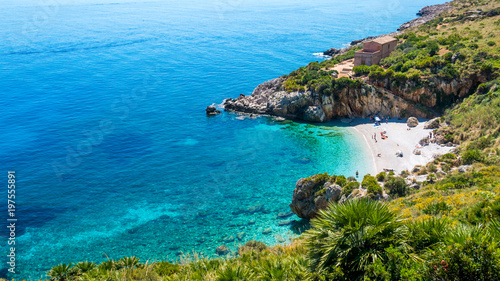 The paradise beach in Italy: perfect turquoise transparent water, white pebbles surrounded by green. Cove named “Cala Tonnarella dell’Uzzo”, Natural reserve “dello Zingaro”, San Vito lo Capo, Sicily.