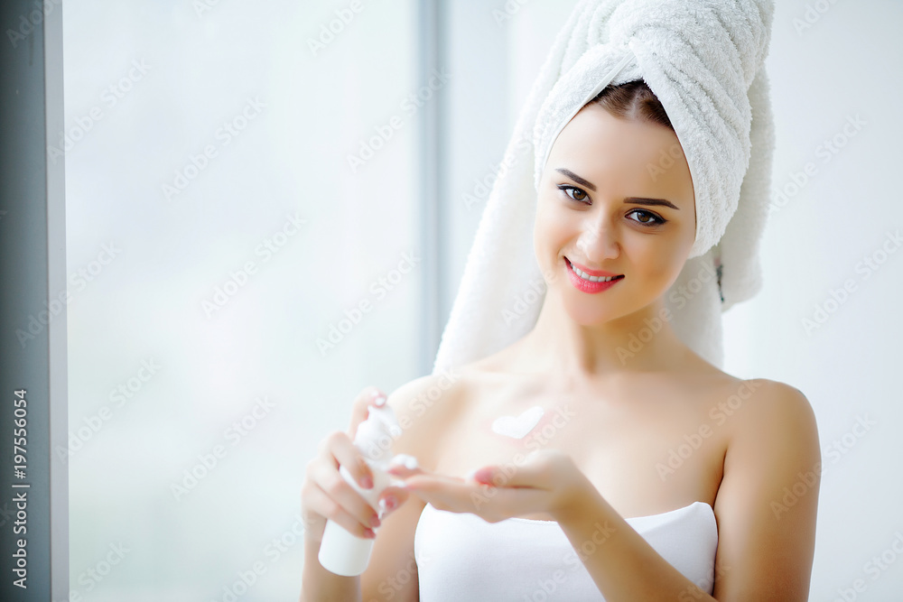 Perfect young woman applying facial cream in bathroom Perfect young woman applying facial cream in bathroom