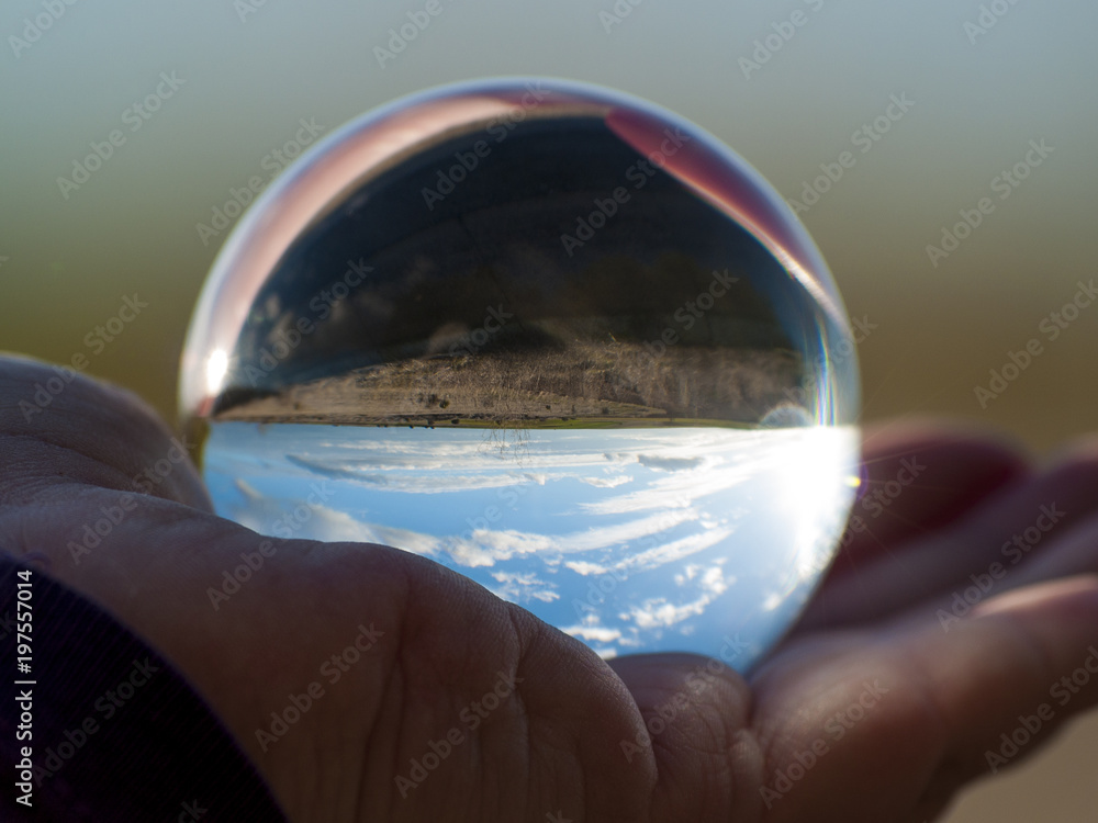 Woman hand holding glass ball with panoramic view of countryside and sky/  Concept for environment Stock Photo | Adobe Stock