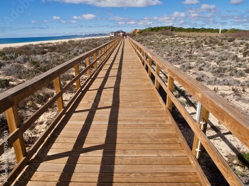 Endlos langer Holzsteg durch die Dünen am Strand der Algarve
