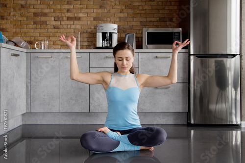 Siddhi's Pose Sitting (Upavista Sthiti)  Beautiful young caucasian woman in her kitchen doing yoga photo