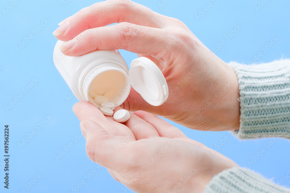 Close up woman pours the pills out of the bottle. Medicine and health care. Close up woman pours the pills out of the bottle. Medicine and health care.