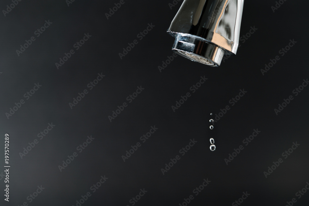 water drop on faucet with  black backgrounds, world water day concept