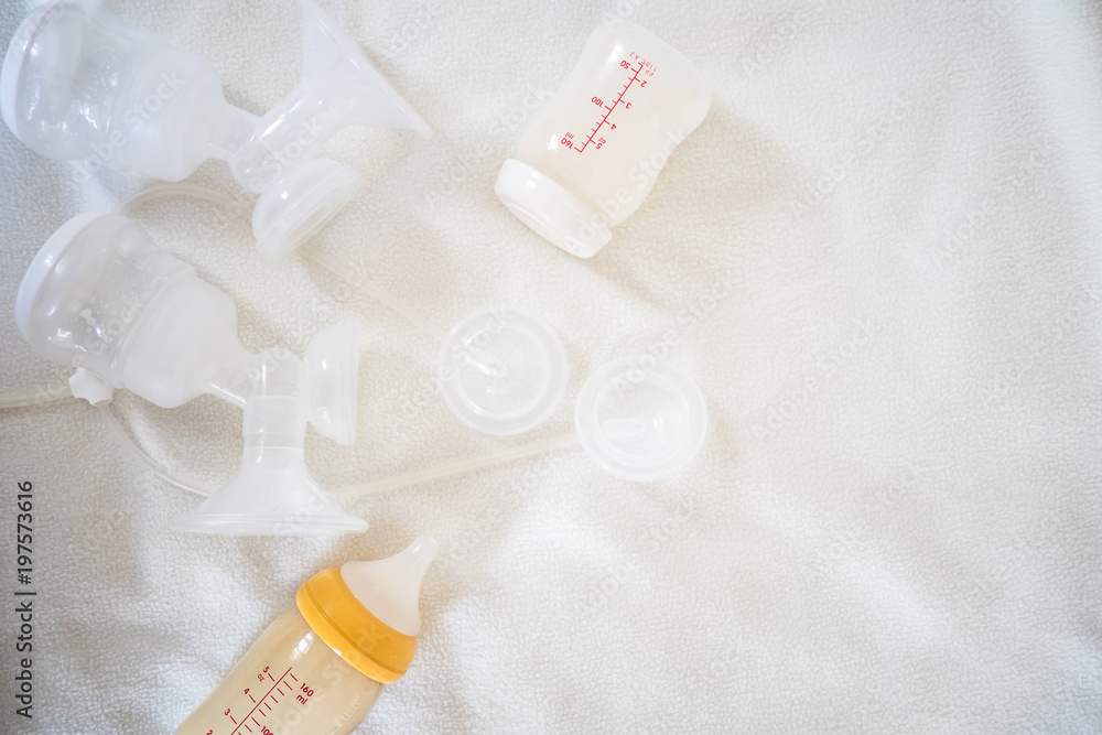 Breast pump equipment and bottle of breast milk for new born baby with white blanket background for text space Breast pump equipment and bottle of breast milk for new born baby with white blanket background for text space