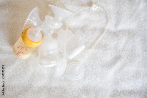 Breast pump equipment and bottle of breast milk for new born baby with white blanket background for text space