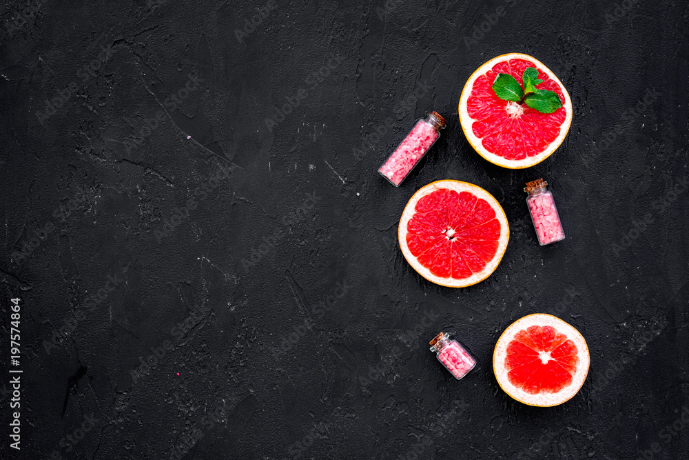 Natural citrus cosmetics with grapefruit salt on black background top view space for text Natural citrus cosmetics with grapefruit salt on black background top view space for text