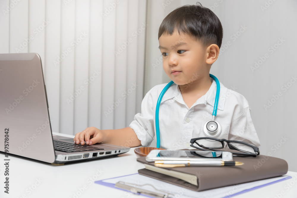 Young asian boy playing doctor and using computer laptop. Young asian boy playing doctor and using computer laptop.