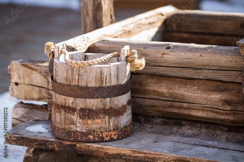 an old wooden bucket stands by the well