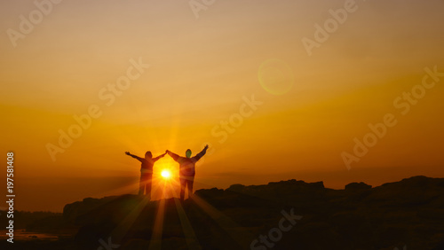 Woman raising her arms on sunrise