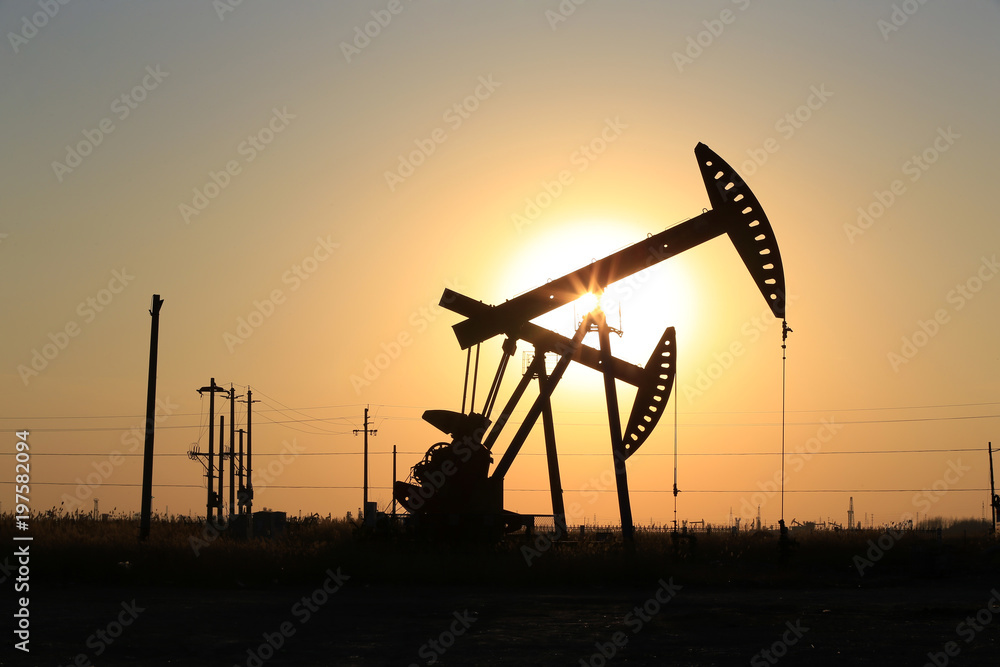 The pumping unit is working in the setting sun The pumping unit is working in the setting sun
