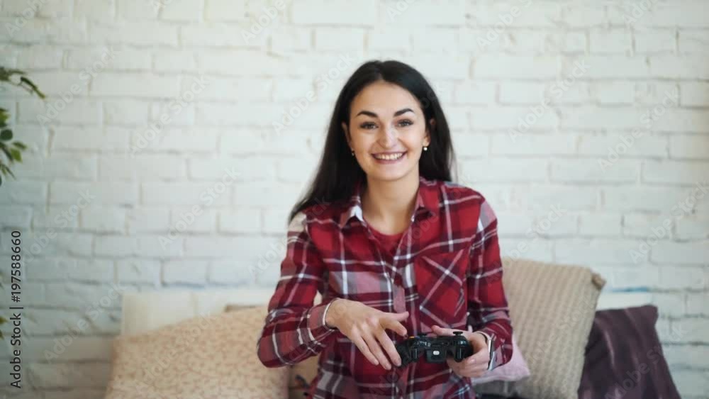 Girl playing on a console on the bed at home. The concept of lifestyle and technology