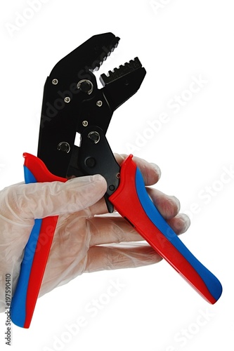 Terminal crimping press pliers with opened jaws, held in left hand in transparent glove used in electrotechnical installations, white background. photo