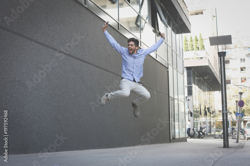 Successful business man jumping high. Man on city street. © Mladen