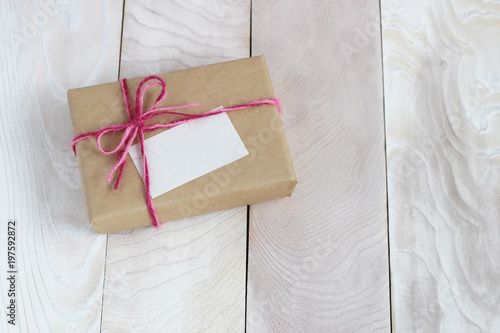 リボンとメッセージカードのついたプレゼントが白い木に置いてある背景