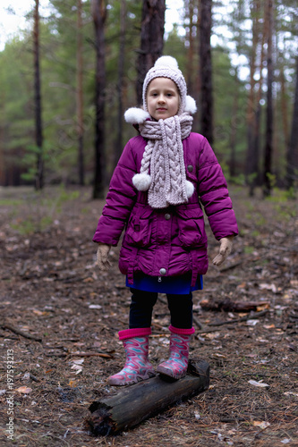 Cute little girl in pine forest in autumn time