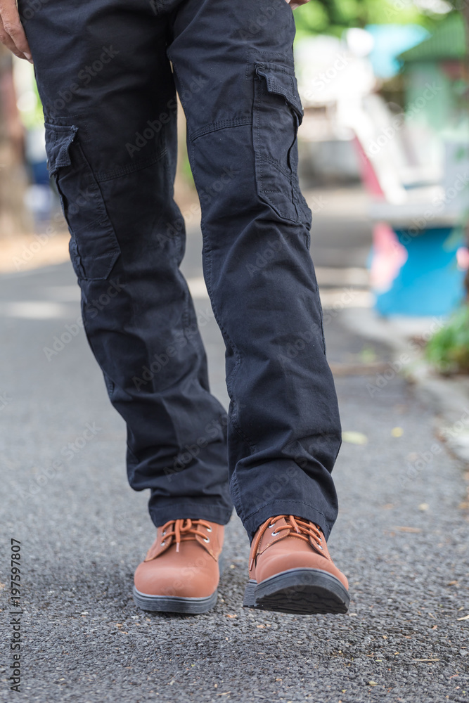 man wearing black cargo pants and standing in the nature park man wearing black cargo pants and standing in the nature park
