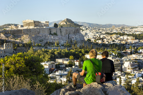 2 guys sitting on a hill opposite the Acropolis in Athens, view of Athens, Greece