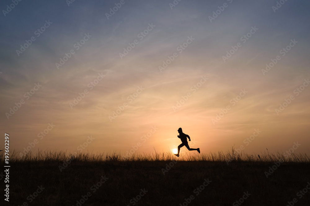 Kid running across the horizon at sunrise