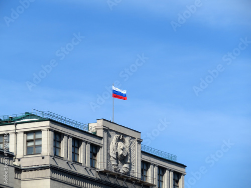 National flag of Russia and the Soviet coat of arms on the Parliament building in Moscow