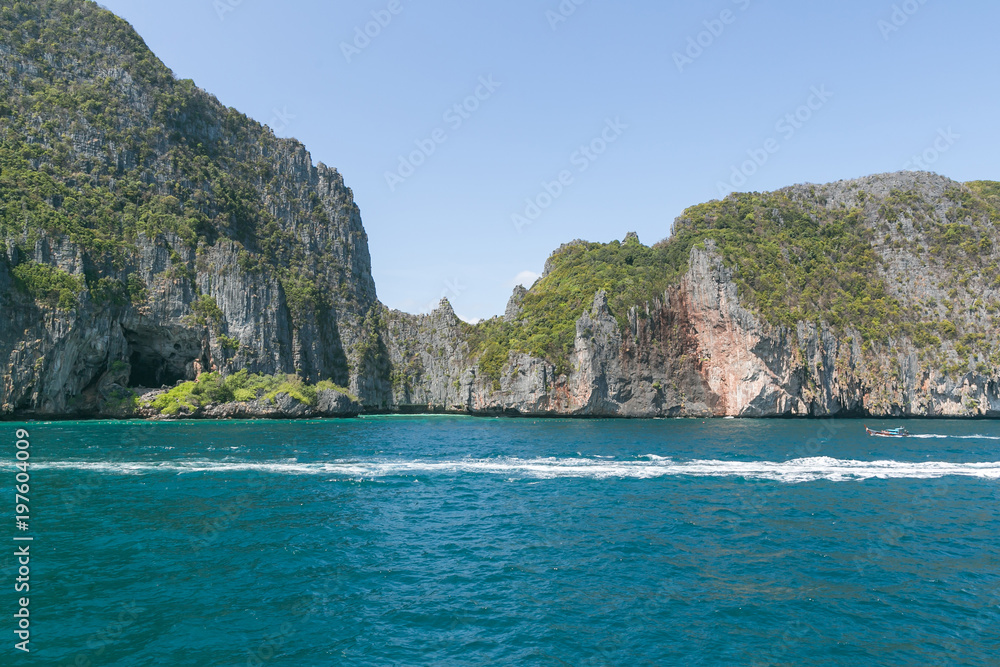 scenic view of rocky formations covered with green plants, blue sky and ocean, phi phi islands scenic view of rocky formations covered with green plants, blue sky and ocean, phi phi islands