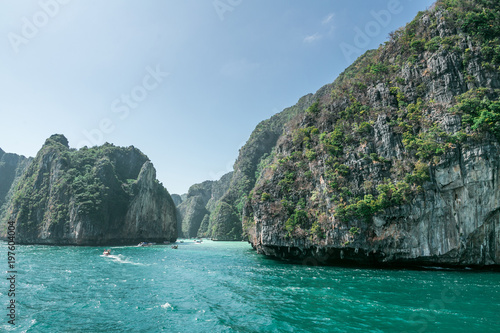 scenic view of rocky formations covered with green plants, blue sky and ocean, phi phi islands