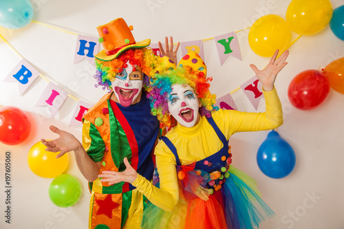 Clowns are a boy and a girl in bright costumes at the child's birthday. The explosion of emotions and the fun of the circus