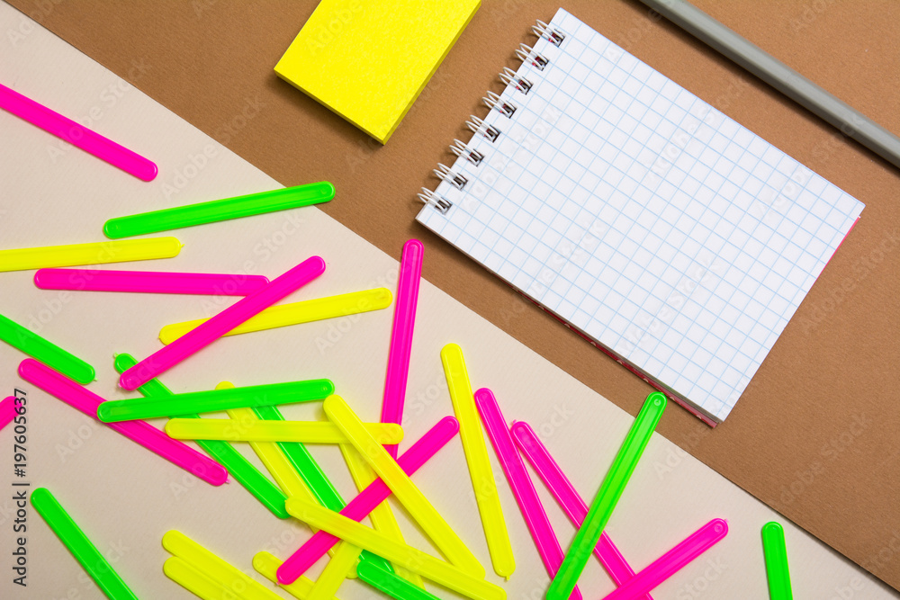 Blank notebook and a bunch of colored counting sticks Blank notebook and a bunch of colored counting sticks