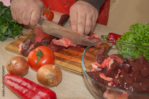 Butcher cutting meat on kitchen. Man in the kitchen cutting a piece of meat