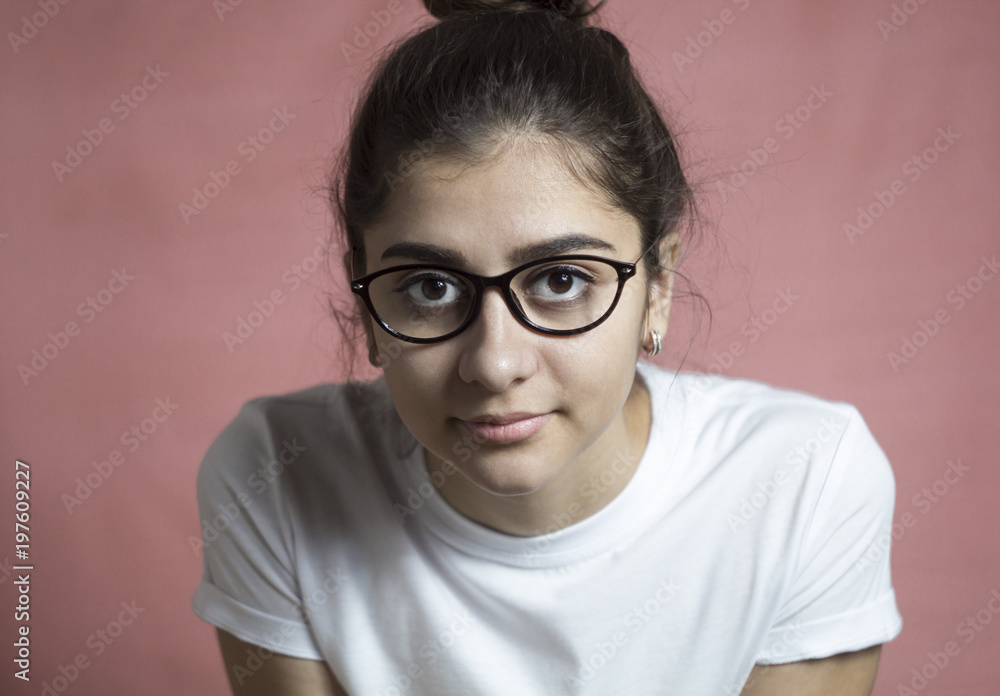Portrait of a beautiful indian girl with glasses looking at the camera. The concept of a smart, modern student.