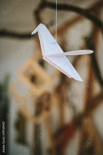 white Origami hummingbirds are hanging on thread