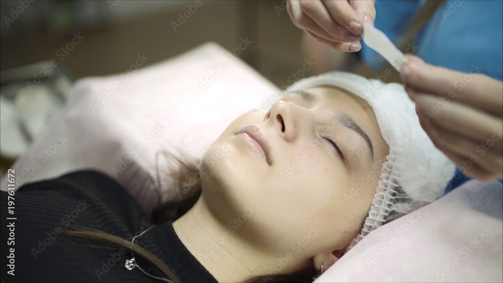 Close up of professional stylist lengthening lashes for female client in a beauty salon. Making permanent make up for woman and eyelash extension procedure special instruments. View from above. Close up of professional stylist lengthening lashes for female client in a beauty salon. Making permanent make up for woman and eyelash extension procedure special instruments. View from above.