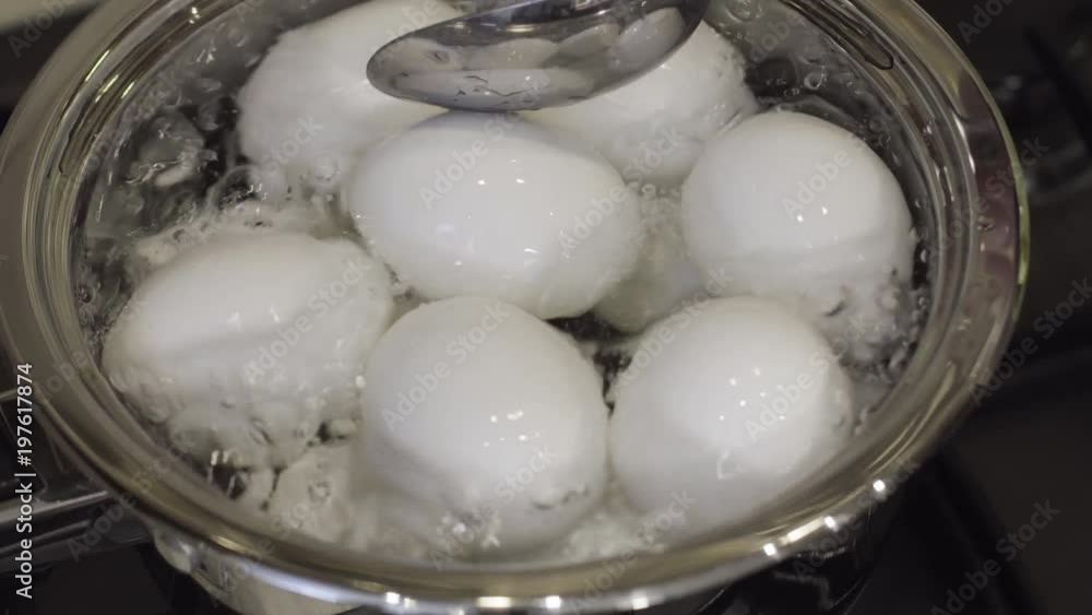 Checking boiling eggs with spoon in the kitchen Checking boiling eggs with spoon in the kitchen