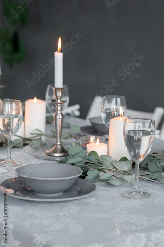 Wedding or festive table setting. Plates, wine glasses, candles and cutlery © Oleg Samoylov