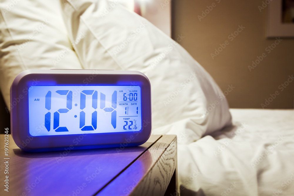 electronic alarm clock stands on a bedside table in the room or hotel room  Stock Photo | Adobe Stock