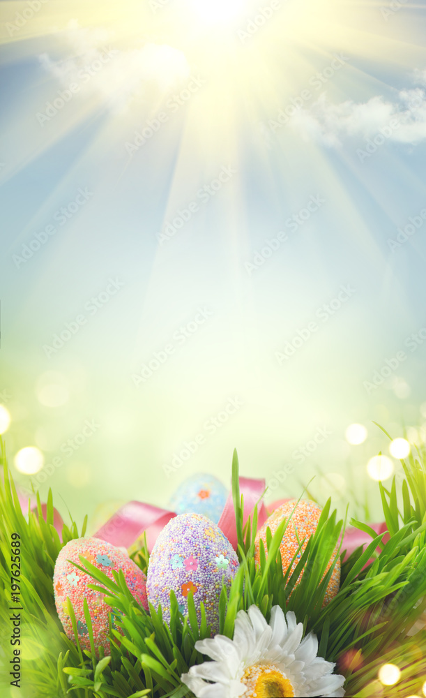 Fototapeta premium Easter holiday scene background. Traditional painted colorful eggs in spring grass over blue sky. Spring holidays Easter backdrop