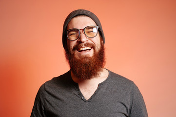 Close up portrait of happy smiling bearded hipster man with eyeglasses and looking confident at the camera