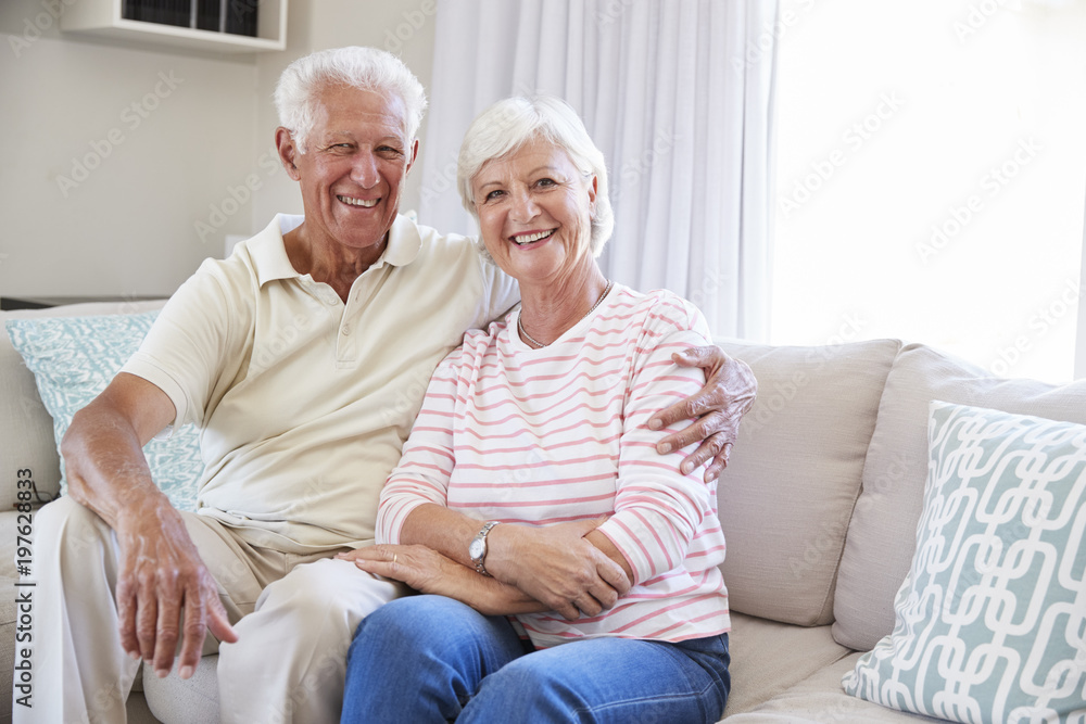 Portrait Of Senior Couple Relaxing On Sofa At Home Together Portrait Of Senior Couple Relaxing On Sofa At Home Together