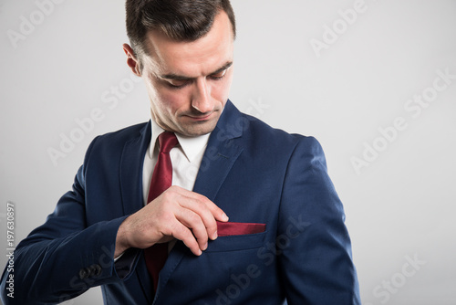 Portrait of business man wearing suit arranging jacket pocket