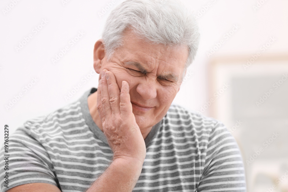 Mature man suffering from toothache at home Mature man suffering from toothache at home