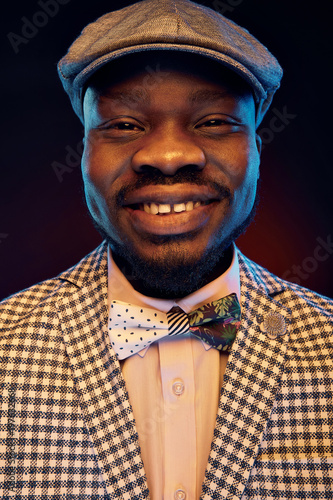 Photography Studio neon portrait of handsome black jazzman with funny smiling face in white