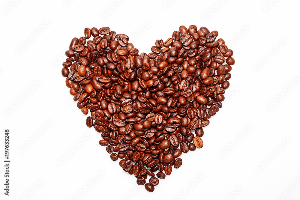 Grains of coffee in the shape of a heart are collected on a white table Grains of coffee in the shape of a heart are collected on a white table