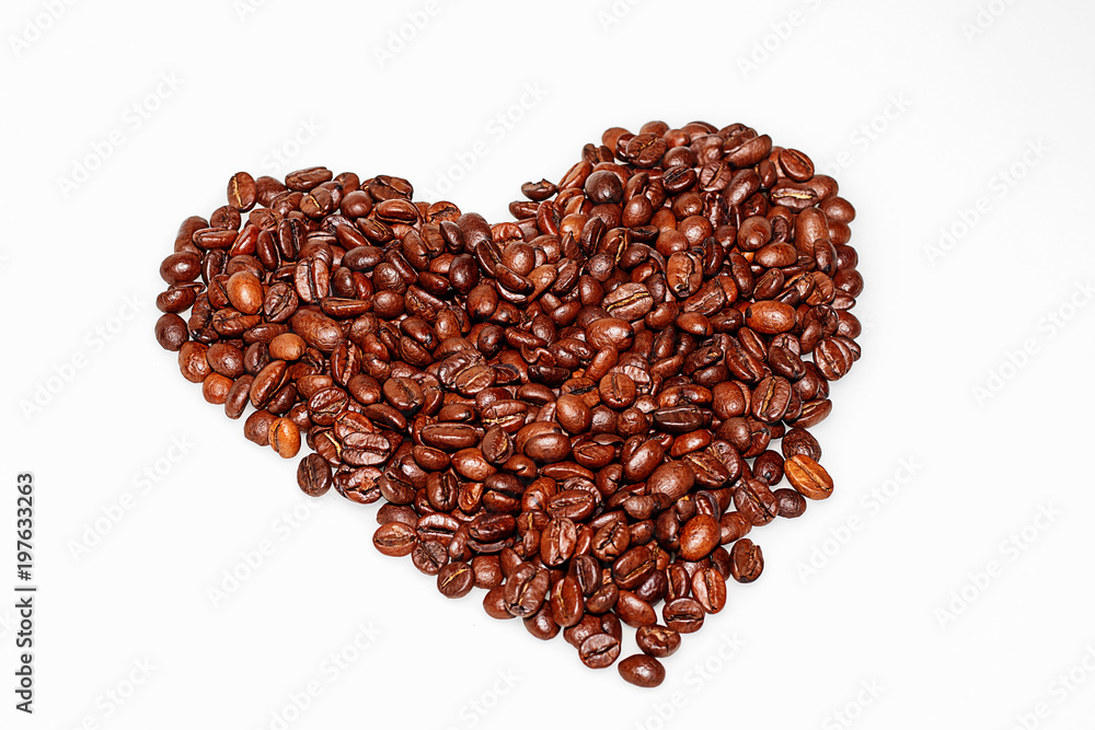 Grains of coffee in the shape of a heart are collected on a white table Grains of coffee in the shape of a heart are collected on a white table