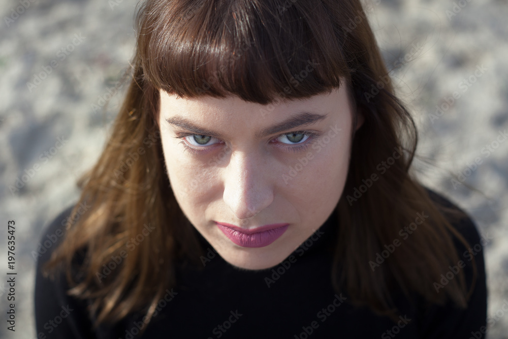 Portrait of young woman with bangs and green eyes looking at camera Portrait of young woman with bangs and green eyes looking at camera