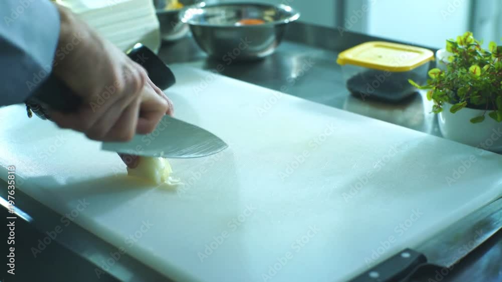 chef cuts onions on the Board in the kitchen chef cuts onions on the Board in the kitchen