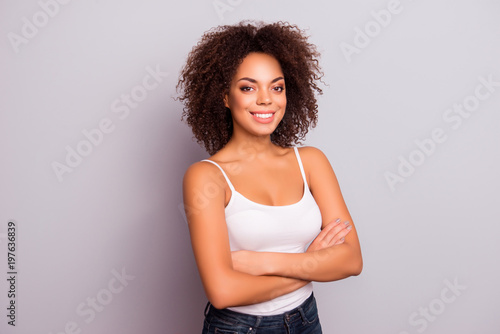 Portrait of cheerful, pretty, cute, attractive, sexy, modern, nice, positive, sweet, content girl having her arms crossed, looking at camera, isolated on grey background